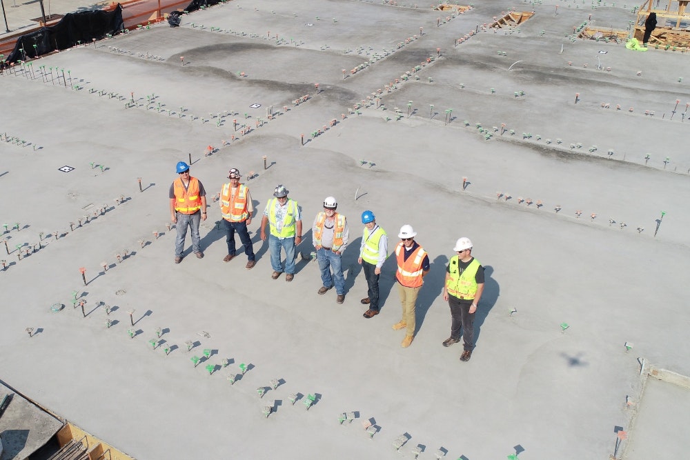 7 workers standing on concrete